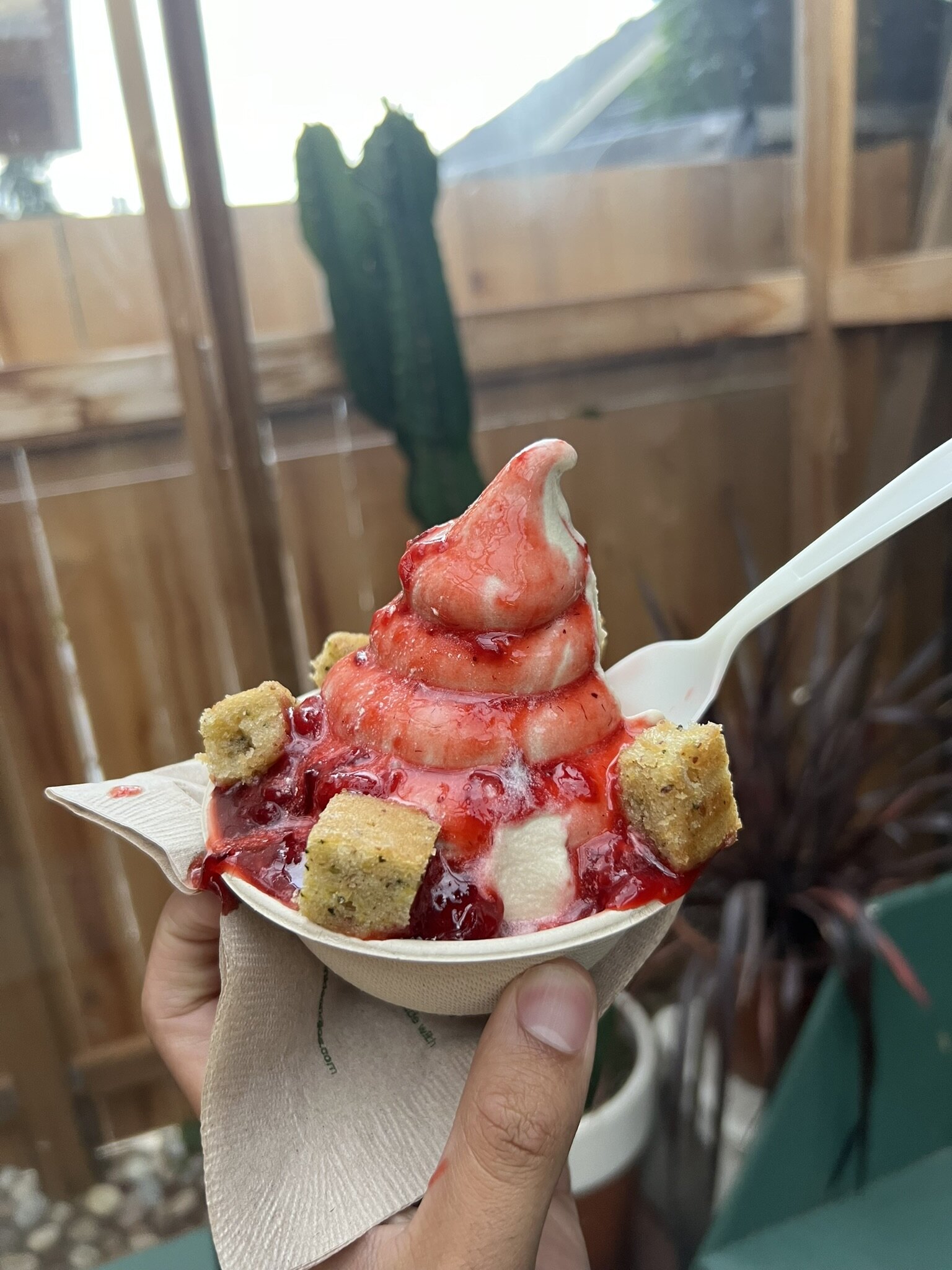 The Strawberry Shortcake sundae. The ice cream is covered in strawberry sauce and garnished with four cubes of zucchini bread around the bowl.