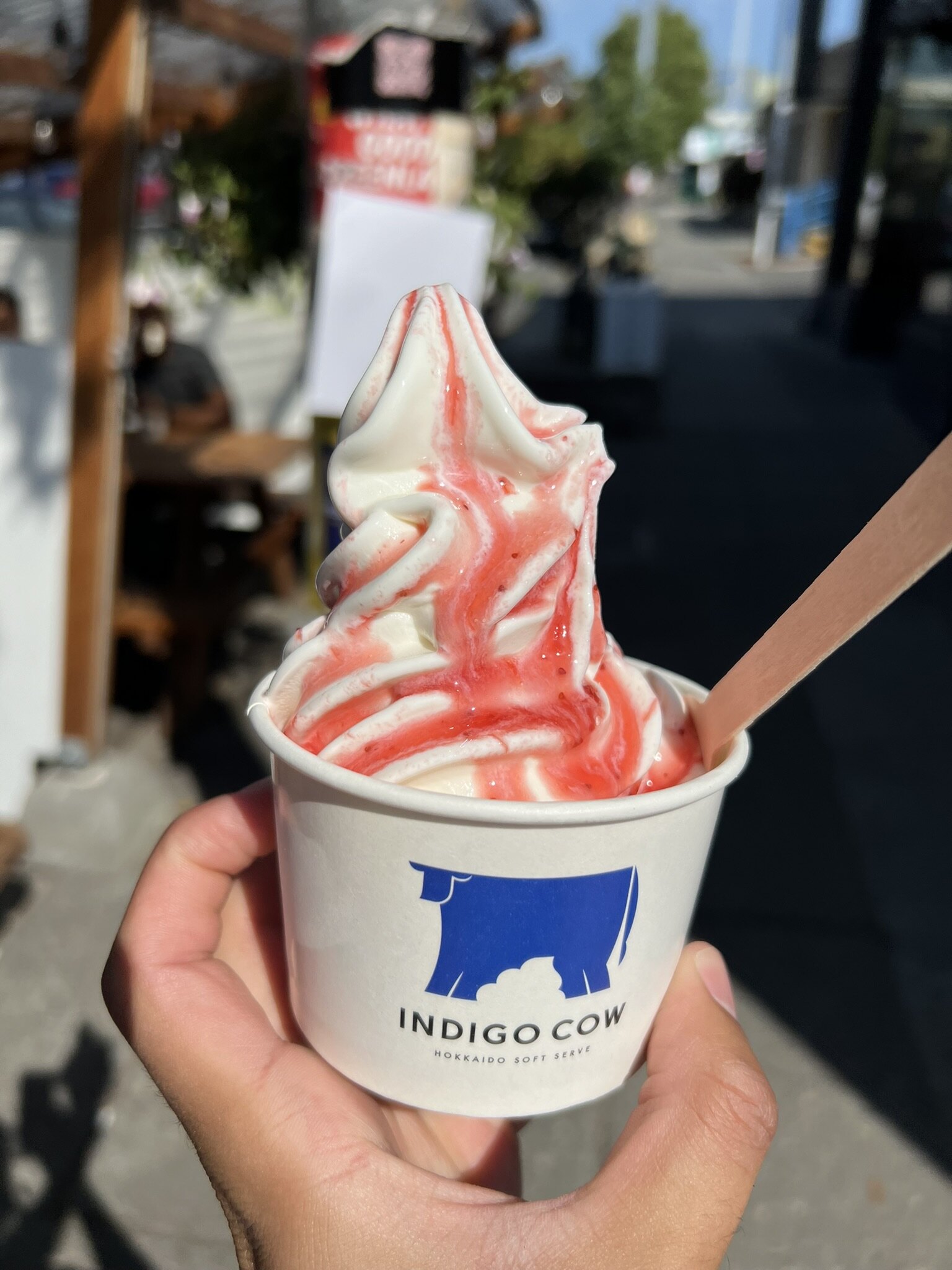 The Hokkaido milk with strawberry sauce in a cup glistening in the sun.